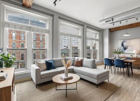 A living and dining space with a view of a historic brick building