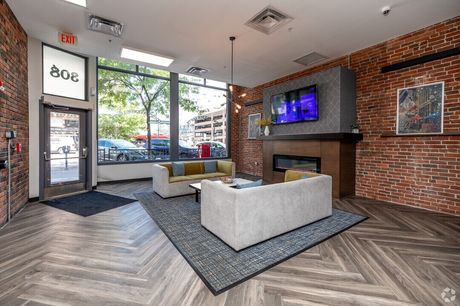The lobby, with exposed brick, a fireplace, and a street-level view of Court Avenue